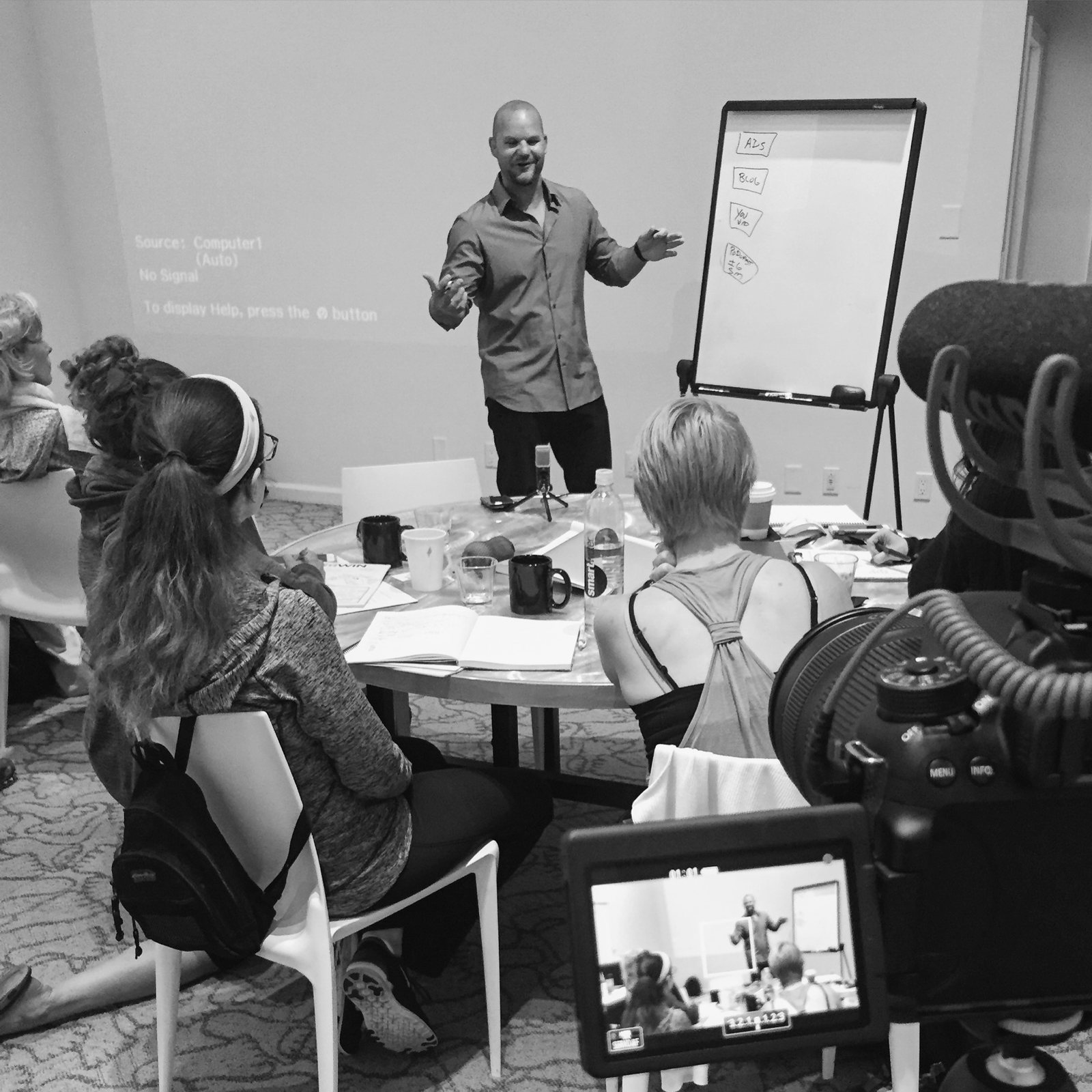 Dr. Jade Teta teaching a room, whiteboard behind him